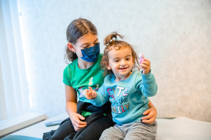 a girl and her younger sister sitting next to each other