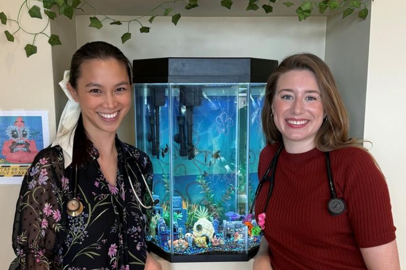two women medical professionals in front of a fish tank