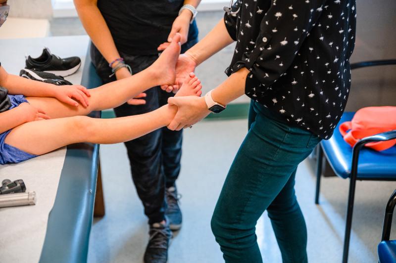 hands pulling on a patients legs
